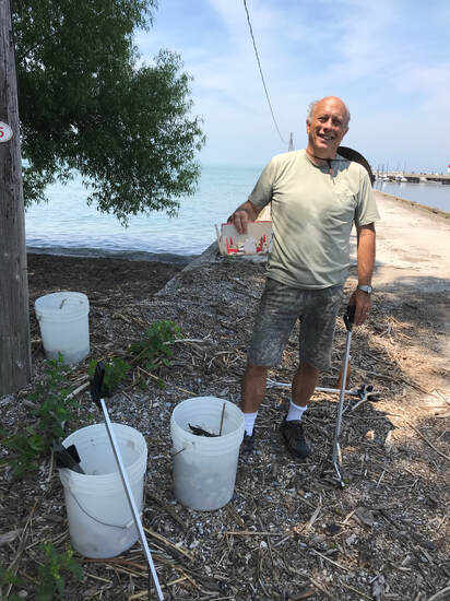 Pelee Eco Works volunteer picking up plastic at the dock on Pelee Island.