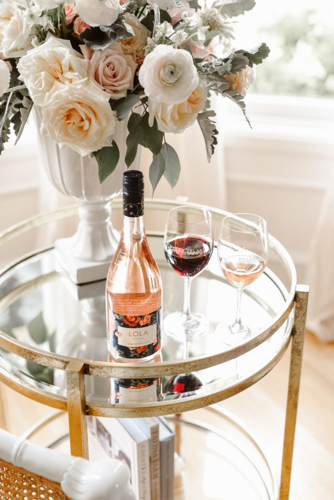 Ready for Valentine's Day with a Bottle and two glasses of Pelee Island Winery LOLA Blush Sparkling Rosé VQA Ontario sitting on a side table with light floral bouquet at The Leslie Styles Vacation Rental house in Kingsville, Ontario