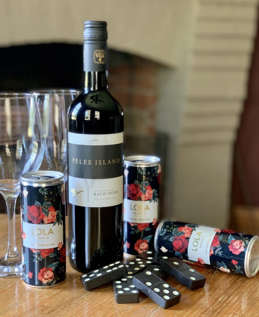 Pelee Island Winery Baco Noir VQA Ontario red wine and Lola Sparkling Blush Rosé 250mL slim cans sitting on table with glasses and domino game.