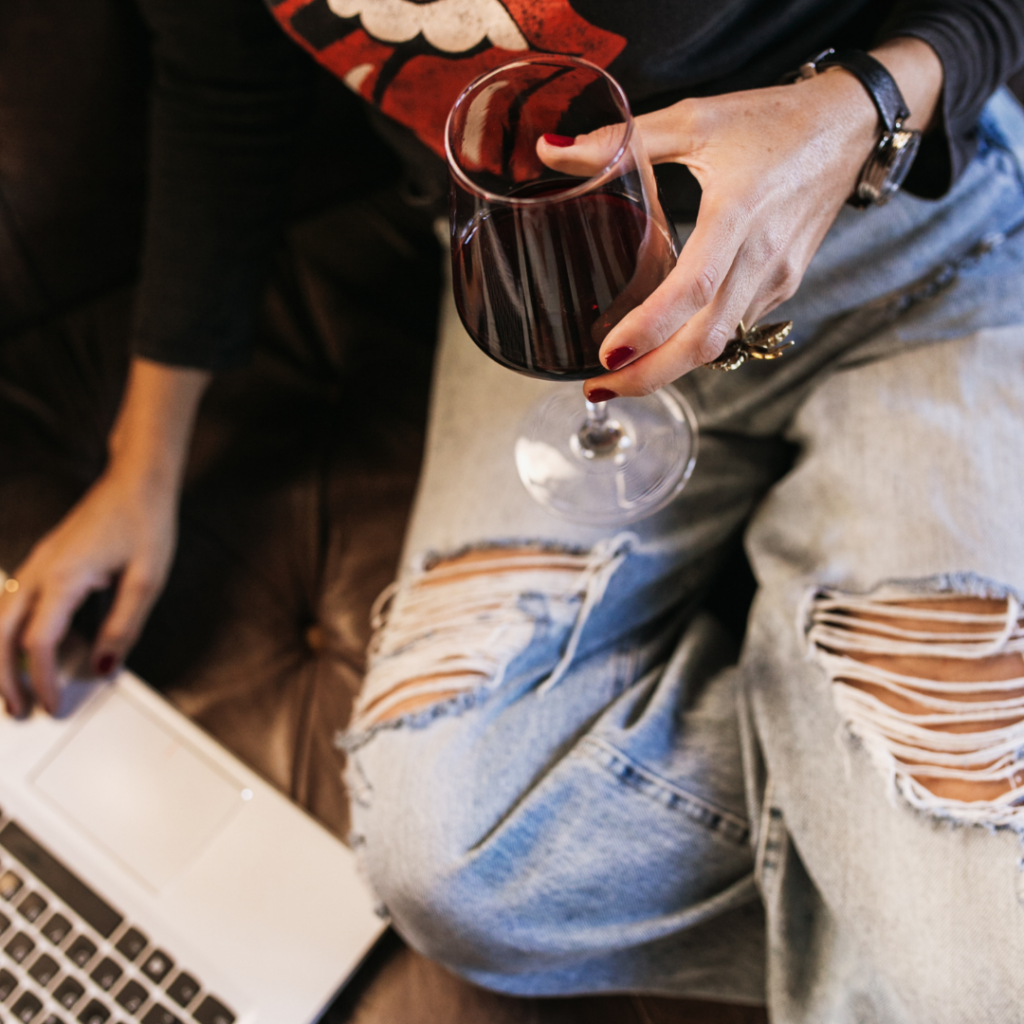 Sipping a glass of red wine while reading about wine online