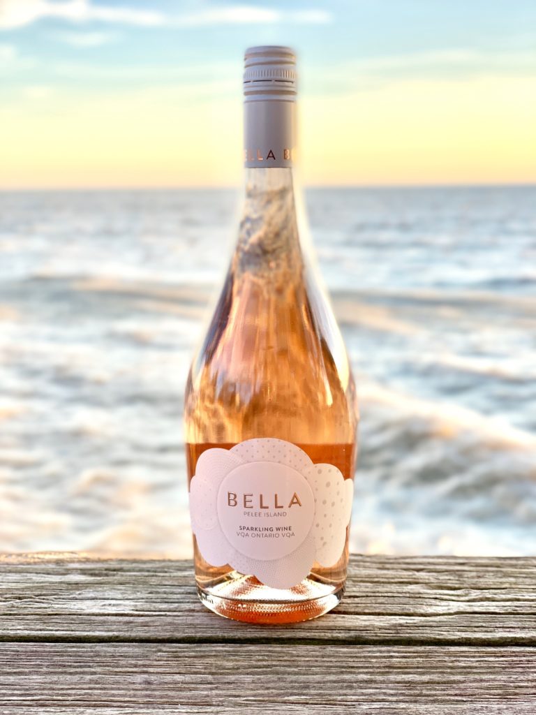 Pelee Island Winery Bella Pinot Noir Sparkling Rosé VQA Ontario wine sitting on dock looking over Lake Erie. 
